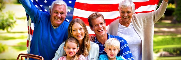 Famiglia multigenerazionale che tiene bandiera americana nel parco