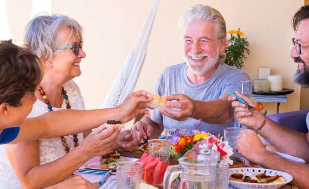 多世代家族グループ、先輩、息子、孫が幸せそうに笑ってお互いを見つめている