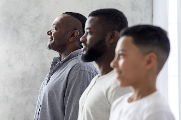 Multigenerational Men Family Portrait. Black Son, Father And Grandfather Standing In A Row, Smiling While Posing, Side View With Selective Focus