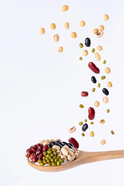 白い背景で隔離の上の木のスプーンでマルチグレイン5種類の豆のスプラッシュストップモーション食べ物や飲み物のオブジェクトのデザイン