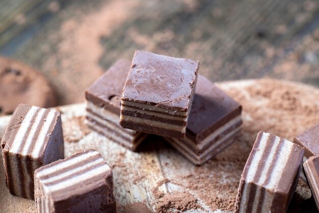 Multilayered sweets made of cream and chocolate layers with different flavors mixed taste of sweets from different ingredients in striped candies