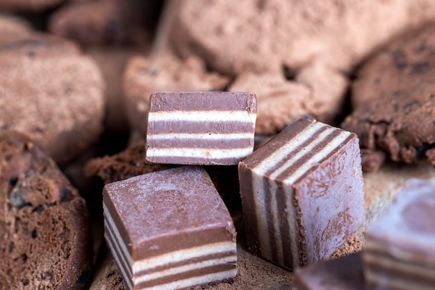 Multilayered sweets made of cream and chocolate layers with different flavors mixed taste of sweets from different ingredients in striped candies