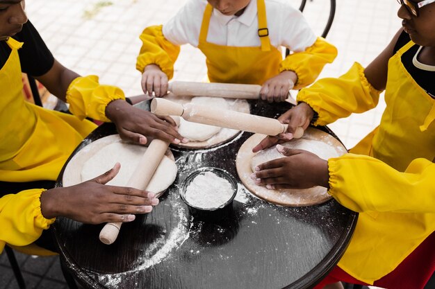 Multinationaal bedrijf van kinderen kookt deeg close-up Jonge koks kinderen koken khachapuri