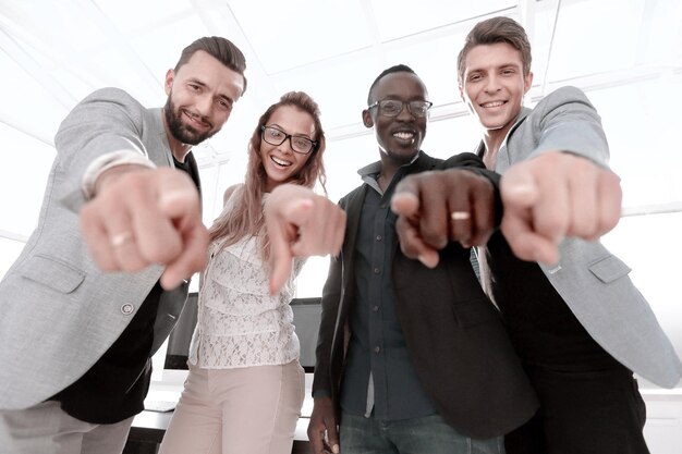 Photo multinational business team points their fingers at you