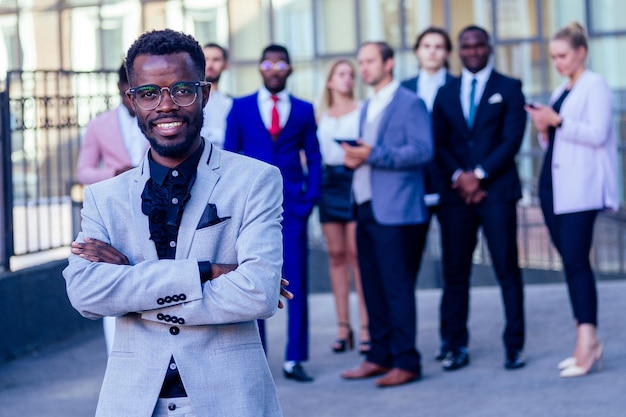 Multinational and multiethnic corporate business people boss\
and colleagues partners standing and smiling on on the street\
background skyscraper windows