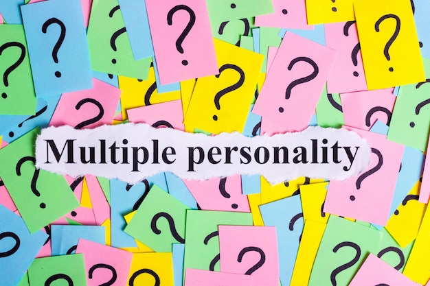 Foto testo di sindrome di personalità multipla su bigliettini colorati contro i punti interrogativi