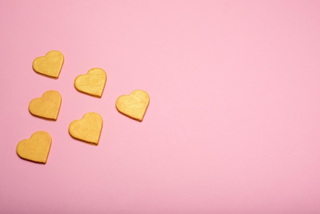 Multiple yellow hearts on a pink background