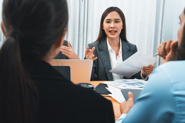 Multiracial analyst team use BI dashboard data to analyze financial report on meeting table Group of diverse business people utilize data analysis by FIntech for business marketing decision Concord