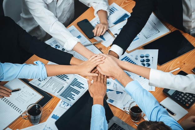 Multiracial business people make synergy hand stack together in meeting room as cooperation or team building for corporate employee in workplace Top view Meticulous