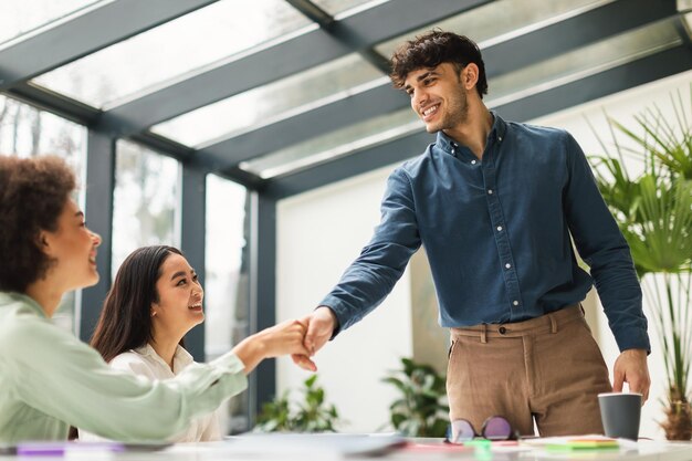 Foto uomini d'affari multirazziali che stringono la mano durante il colloquio di lavoro in ufficio