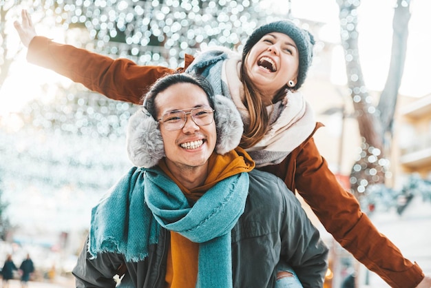 Multiracial couple in love wearing winter clothes celebrating Christmas holiday