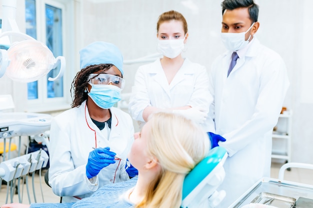 Squadra dentale multirazziale con paziente in clinica dentale. concetto di salute dentale.