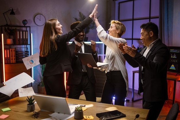 Multiracial diverse business people in formal wear celebrating success at work and gesturing