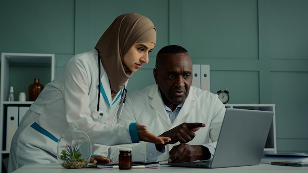 Multiracial doctors colleagues discuss teamwork african man and arabian woman two professional