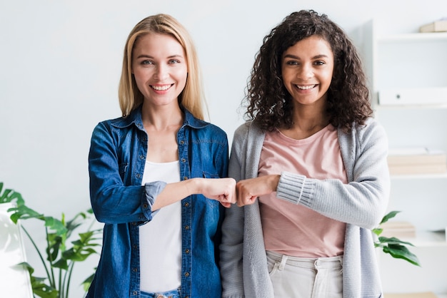 Photo multiracial employees bumping fists at office