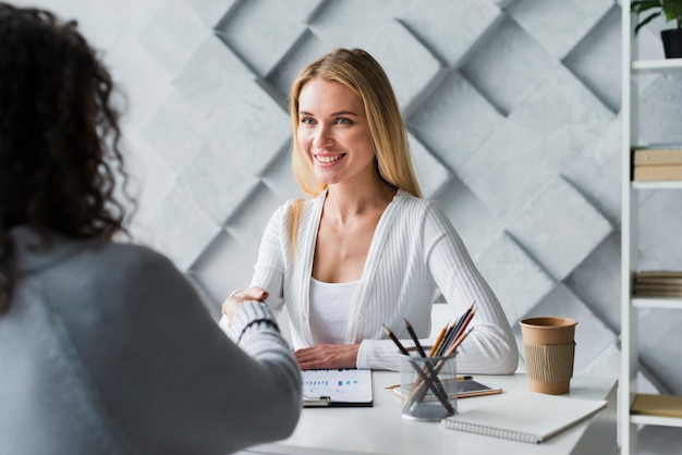 Multiracial employees shaking hands in office