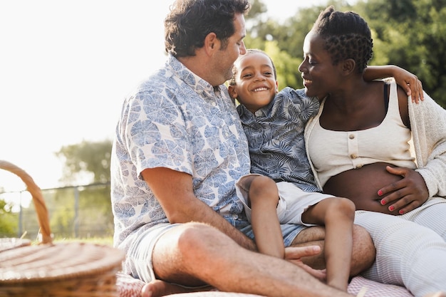 Multiracial family having tender moment doing picnic outdoor at city park  Focus on kid face
