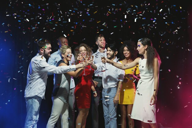 Multiracial friends clinking glasses at New Year party