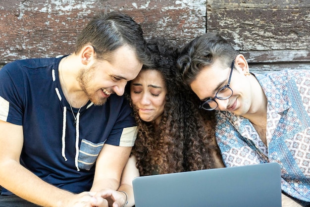 Multiracial friends having fun with laptop during a video call outdoors Connected community of young students people using pc on social media networks Z generation concept sharing content online