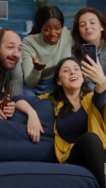 Multiracial friends speaking with collegue man during video call conference using modern smartphone