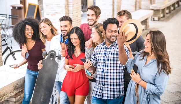 Multiracial friends walking and talking in city center