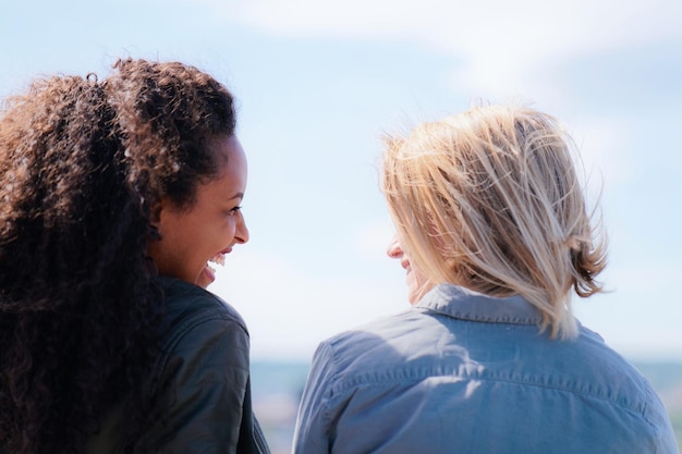 Photo multiracial friends with dutch blonde and beautiful mixed race girl looking at each other and smiling as part of diversity friendship and togetherness concept