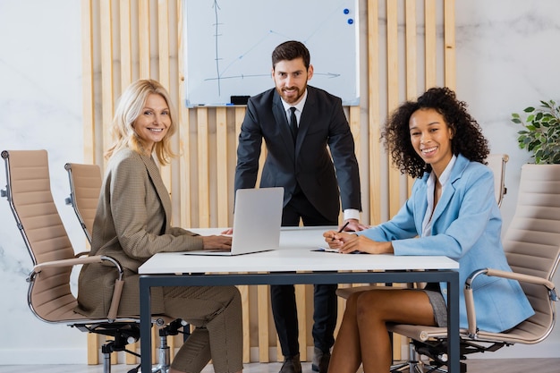 Multiracial group of businesspeople with elegant dress sitting at computer desk in the office