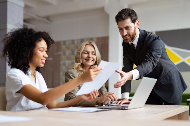 Multiracial group of businesspeople with elegant dress sitting at computer desk in the office