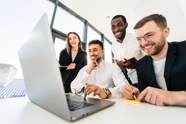 Multiracial group of entrepreneurs working at laptop