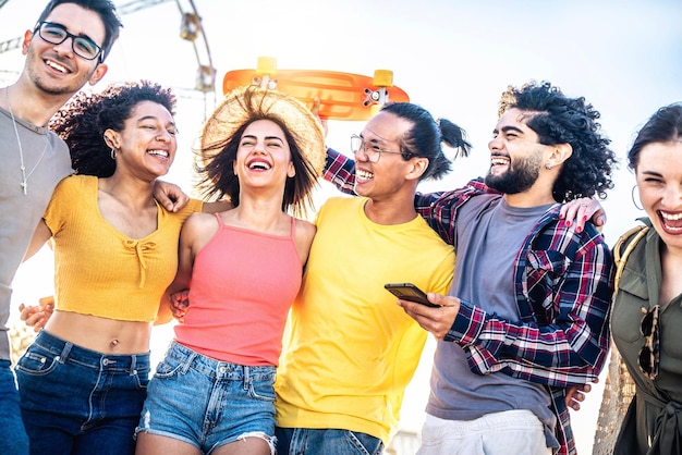 Multiracial group of friends smiling together hanging outside on a sunny day