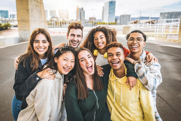 Multiracial group of friends taking selfie picture outdoors