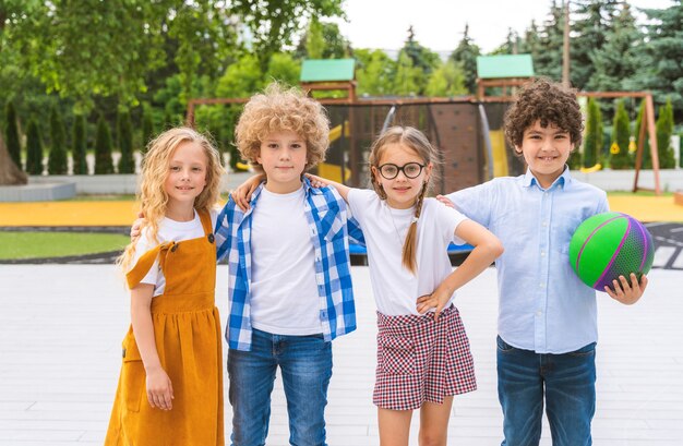 休憩中に遊び場で遊ぶ子供たちの多民族グループ-楽しんでいる遊び心のある小学生