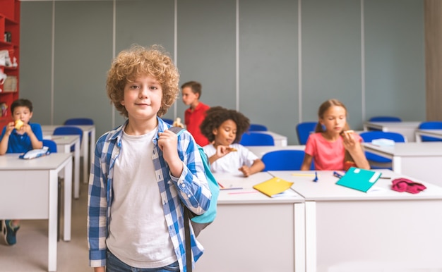 小学校の子供たちの多民族グループ-教師やクラスメートと一緒に学校の時間とレッスンを楽しんでいる遊び心のある学校の生徒