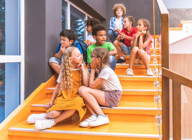 Multiracial group of kids at primary school - Playful schoolers enjoying school time and lesson with teacher and classmates