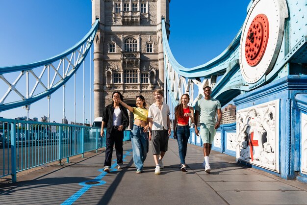 写真 ロンドン市で結びついた幸せな若い友人の多民族グループ 多民族のティーンエイジャーの学生がタワーブリッジエリアで会って楽しんでいる イギリス 若者のライフスタイルの旅行と観光に関するコンセプト