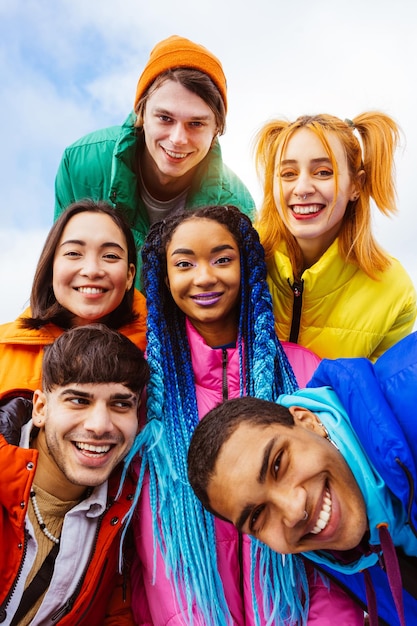 Foto gruppo multirazziale di giovani amici che si incontrano all'aperto in inverno