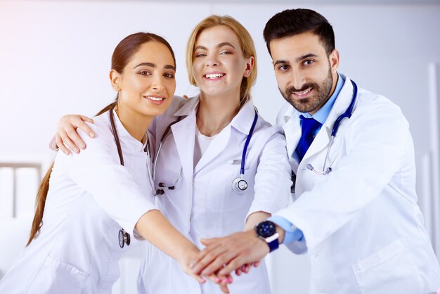 Multiracial medical team stacking hands in hospital