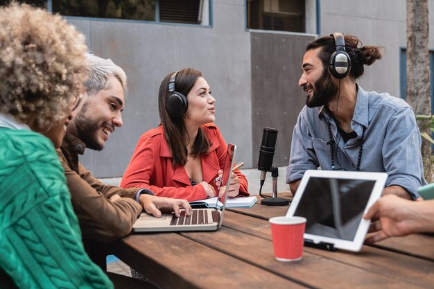 Multiracial people live streaming podcast outdoor focus on\
center girl talking on microphone