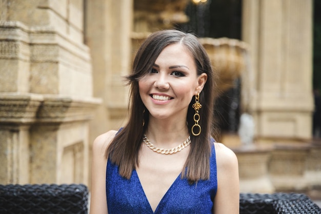 Multiracial pretty smiling woman in blue dress outdoor portrait