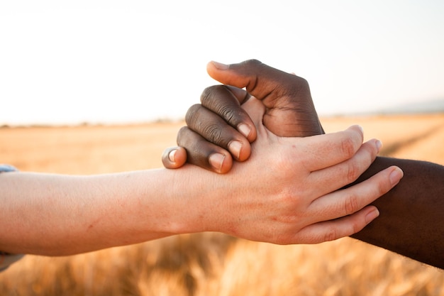 Multiracial relationship and friendsip concept Two hands holding together