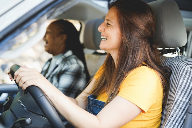 Photo multiracial senior friends having fun on the road with mini van camper  focus on right female hair