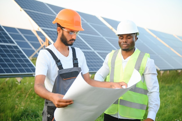 Multiracial team of engineers on solar panels African american and arab engineer working on solar panel farm