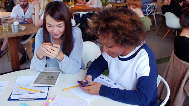 Photo multiracial university students sitting together in coffee shop at table