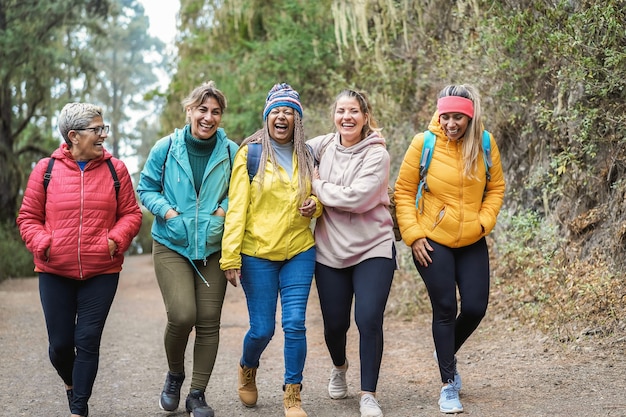 Multiracial women having fun during trekking day in to the wood - Focus on african woman face