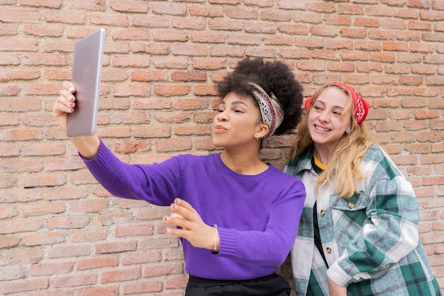 Multiracial women taking photos in the city