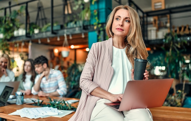 Multiraciale creatieve mensen in moderne kantoren. Groep jonge zakenmensen en senior baas werken samen met laptop, tablet, smartphone, notebook, grafieken. Succesvol team in coworking