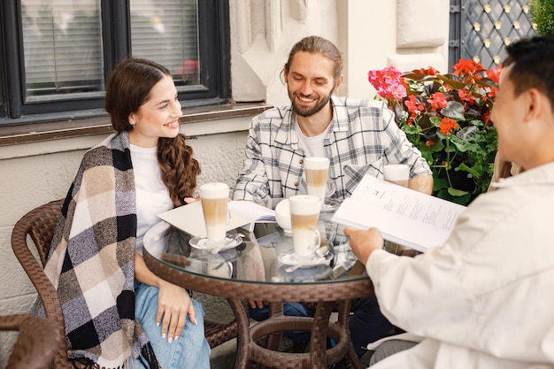 Foto multiraciale groep vrienden die samen koffie drinken in een café buitenshuis