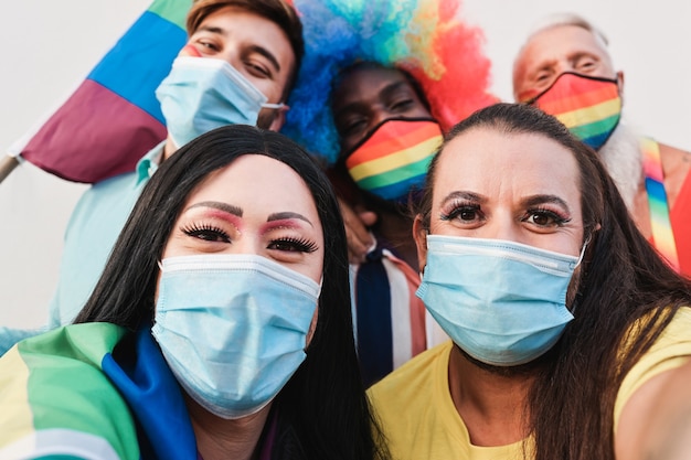 Multiraciale homovrienden die een selfie nemen tijdens de lgbt-parade tijdens de uitbraak van het coronavirus