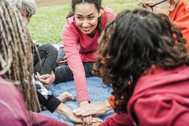 Multiraciale mensen stapelen handen buiten in het stadspark Focus op het gezicht van een Afrikaans meisje