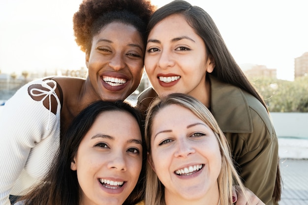 Multiraciale vrienden die samen plezier hebben met selfie buitenshuis - Focus op het gezicht van een Afrikaans meisje